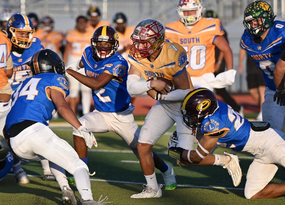 South team quarterback Eleazar Garcia of Golden Valley runs the ball during the Central California Lions All-Star Football Game as North defenders close in at Tracy High School.